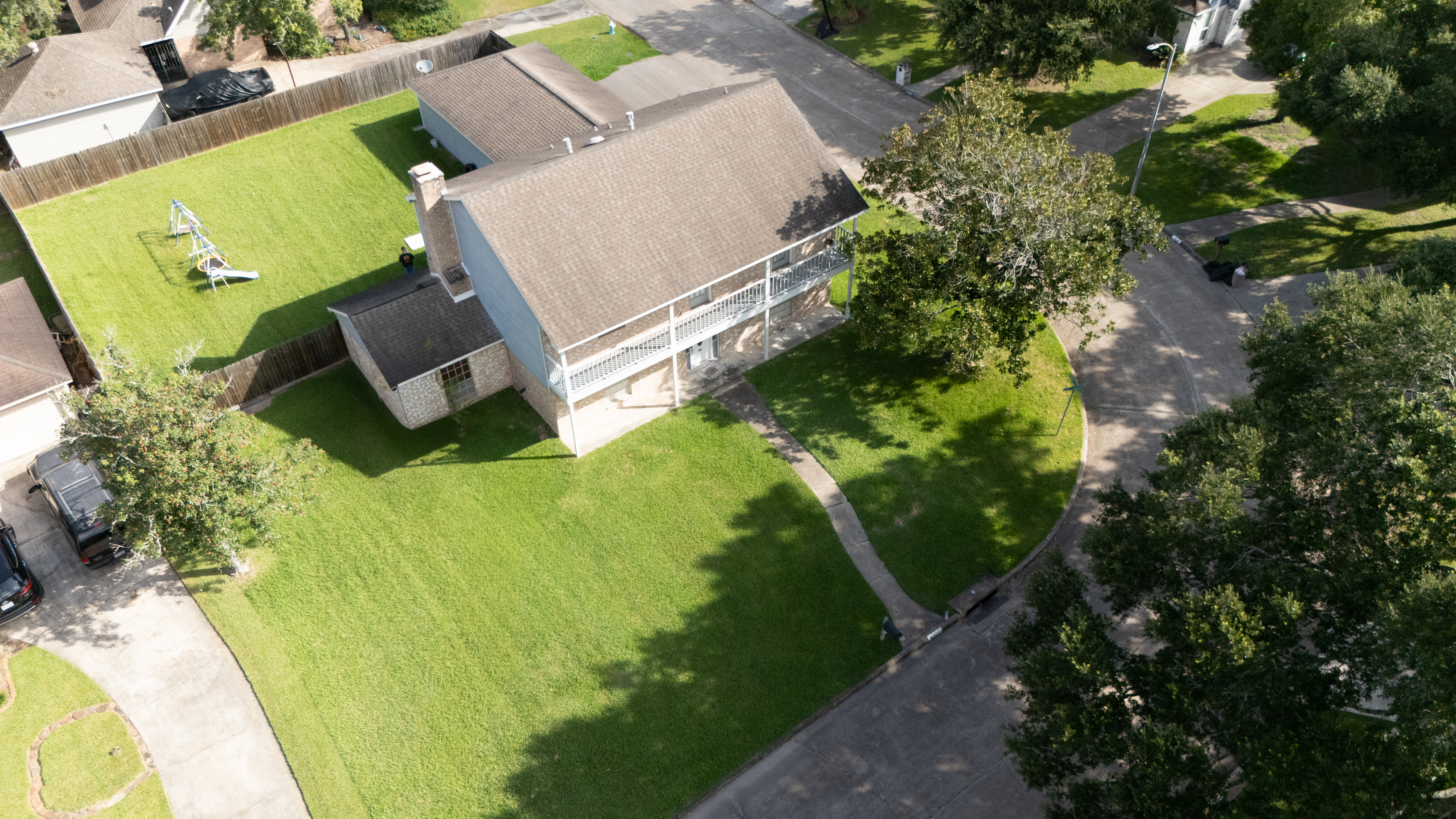 High aerial view showing a home, yard, and surrounding streets