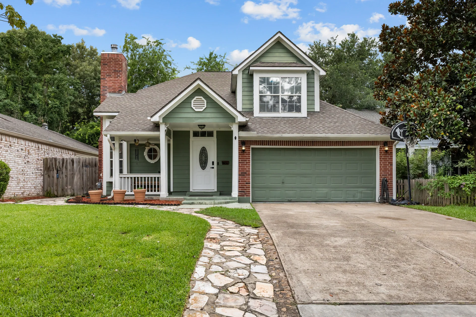 Straight-on front exterior of a green suburban home