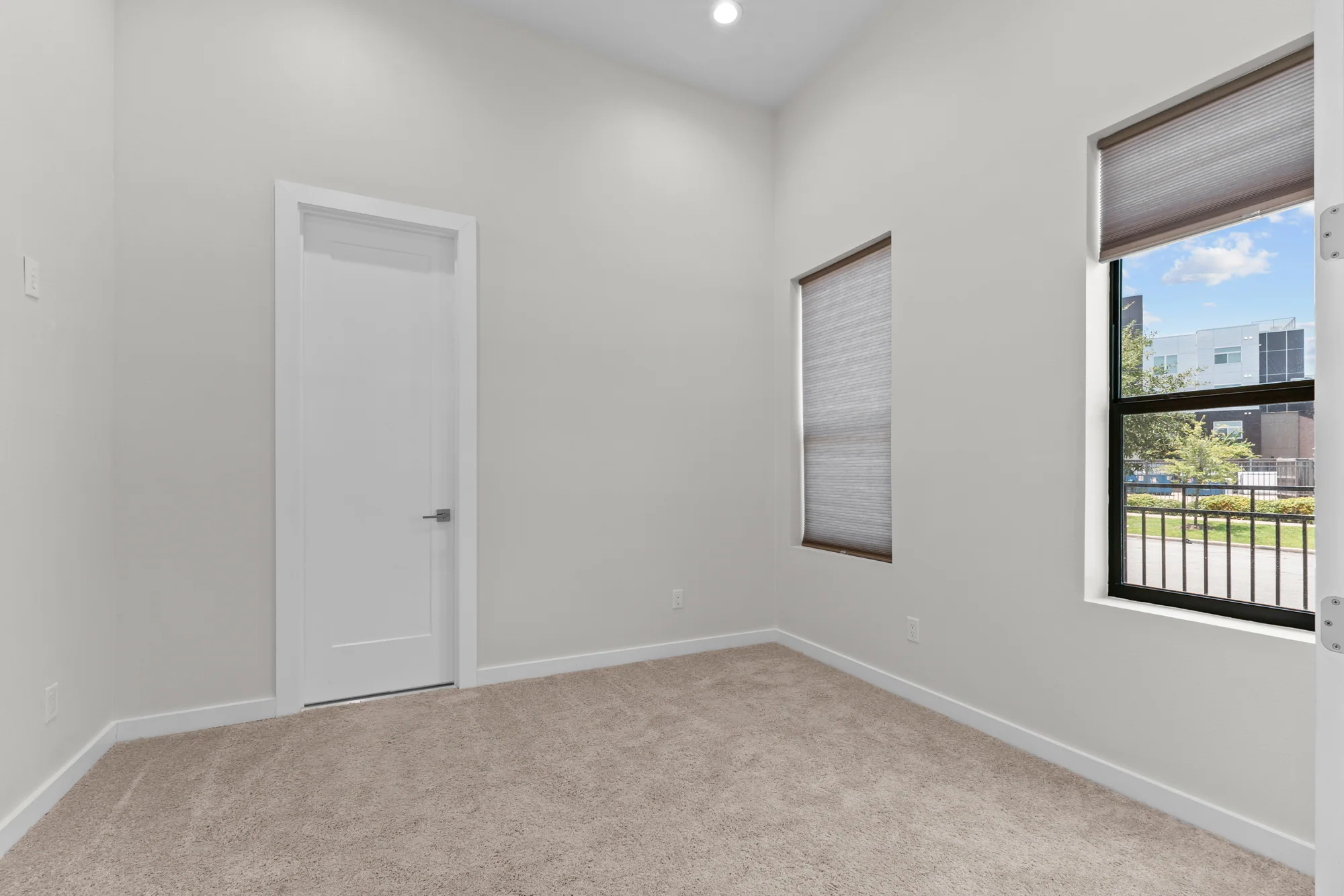 Bright empty bedroom with two tall windows