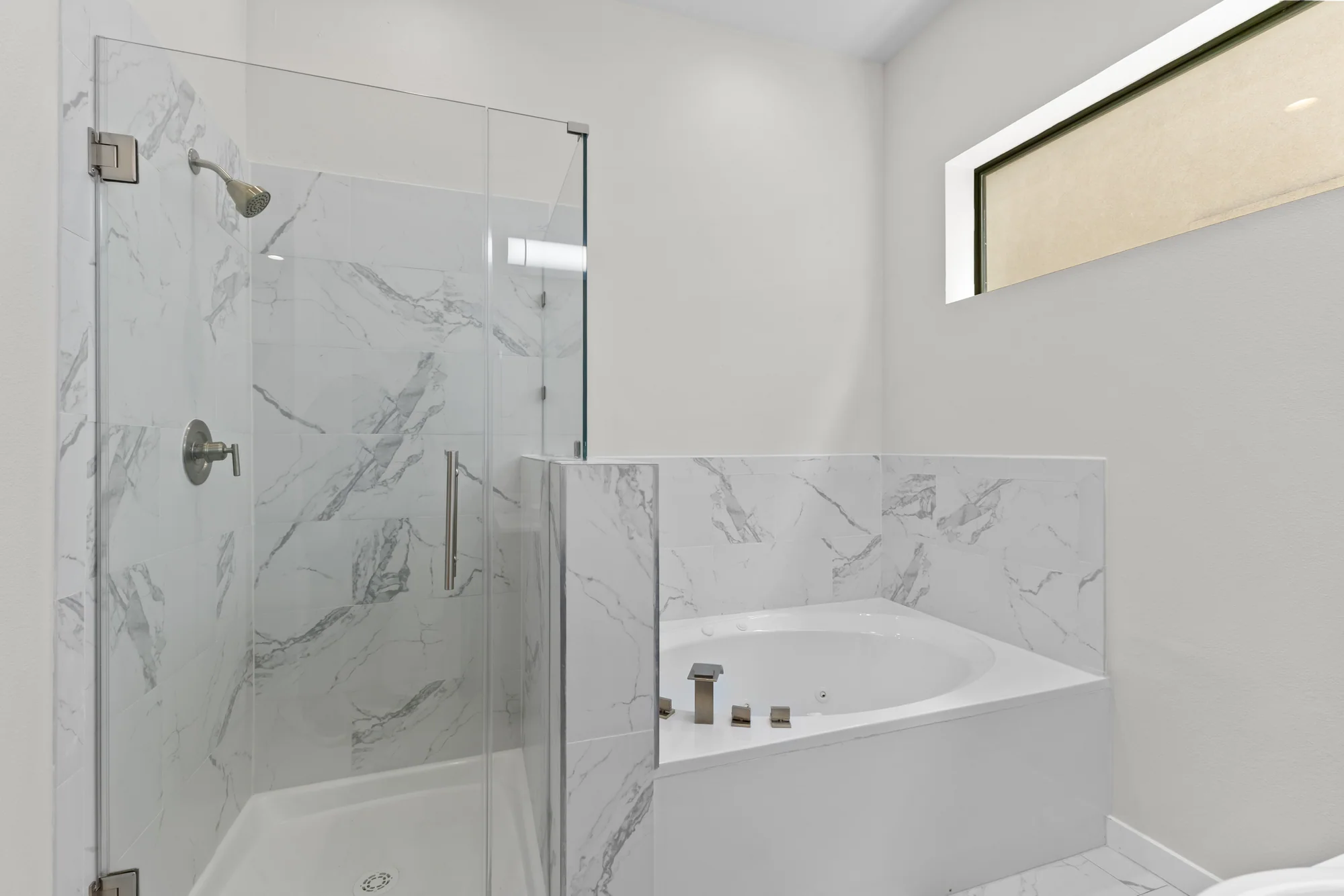 Primary bathroom with glass shower and corner soaking tub