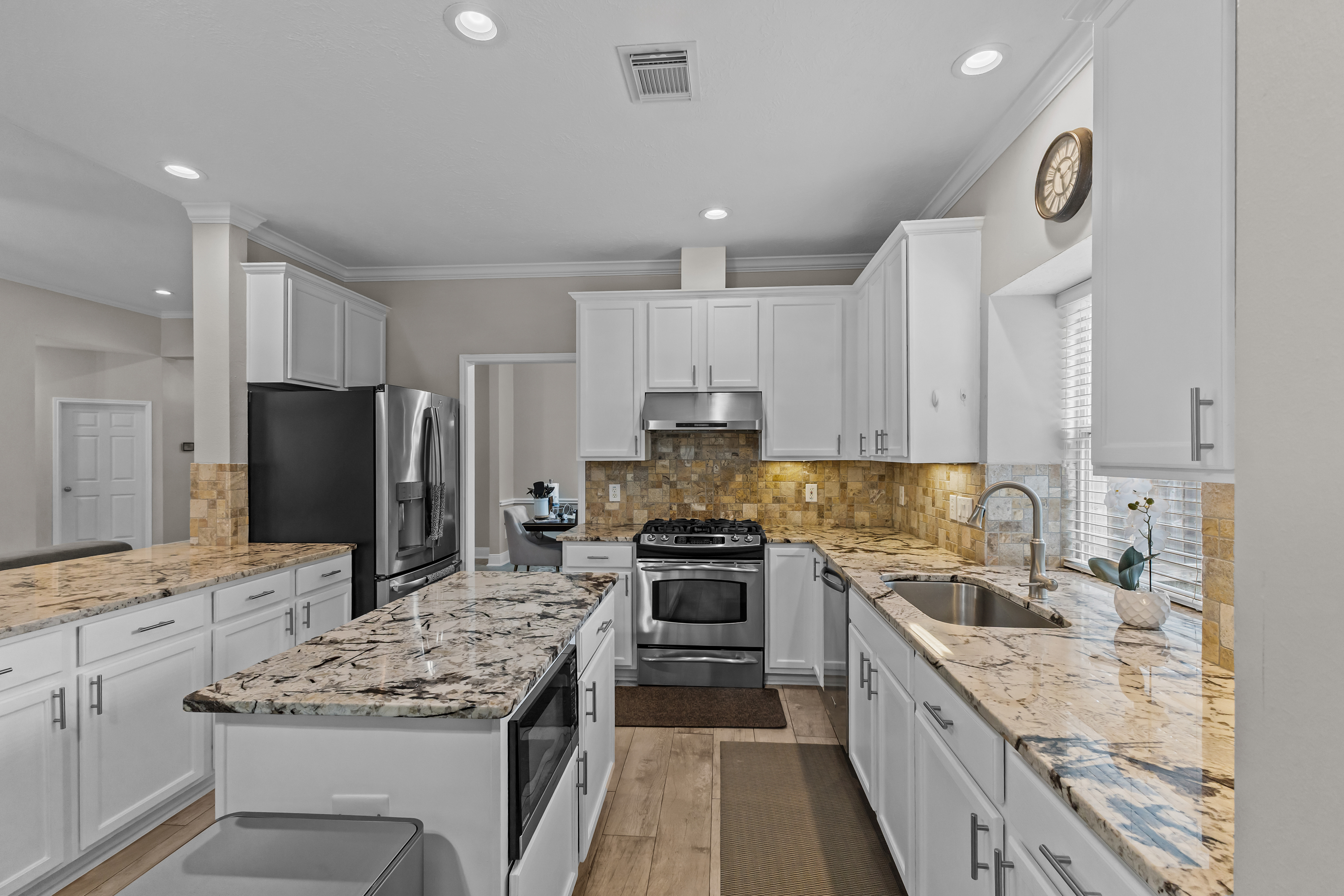 Wide view of a bright kitchen with stainless appliances