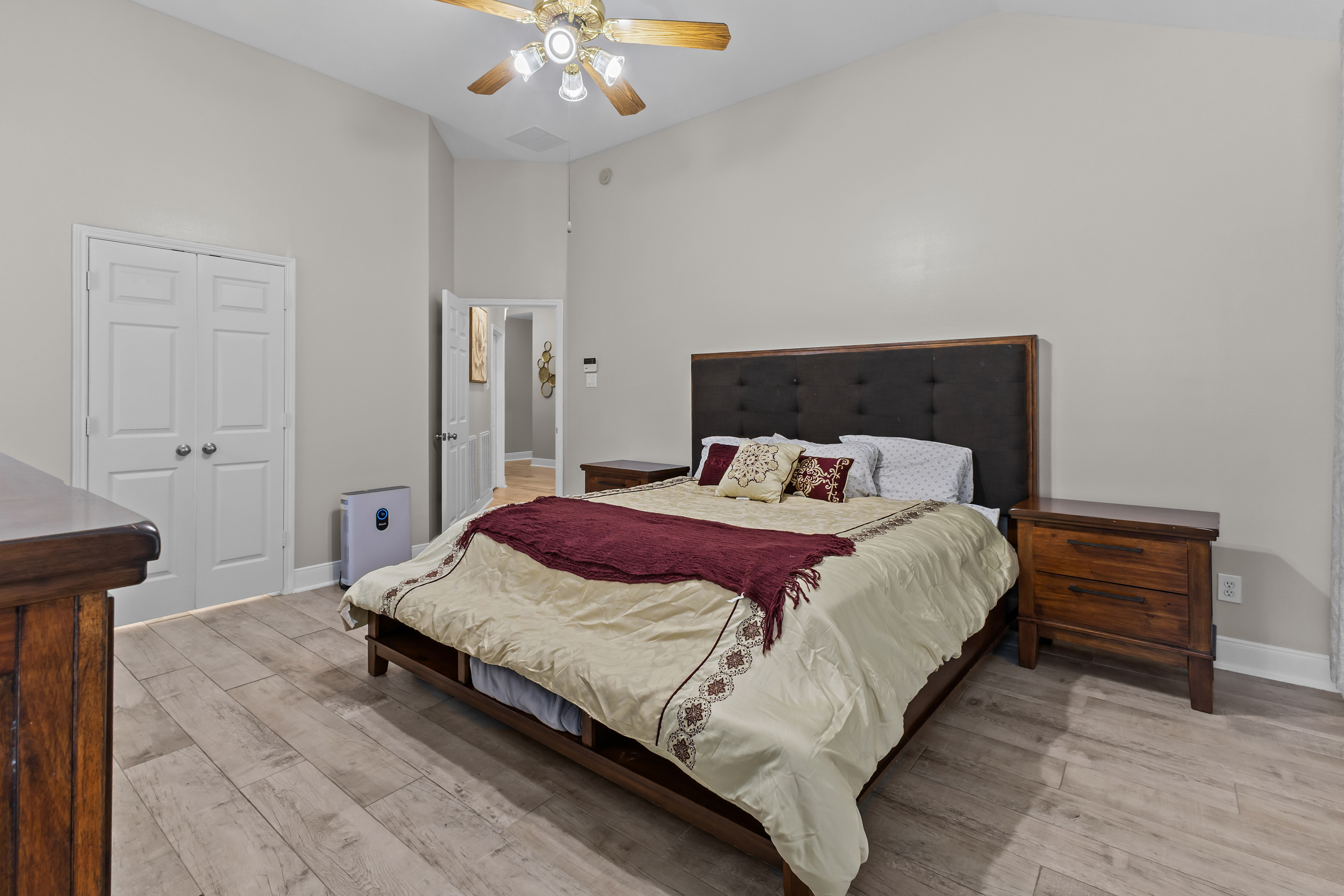 Primary bedroom with wood bed and neutral finishes
