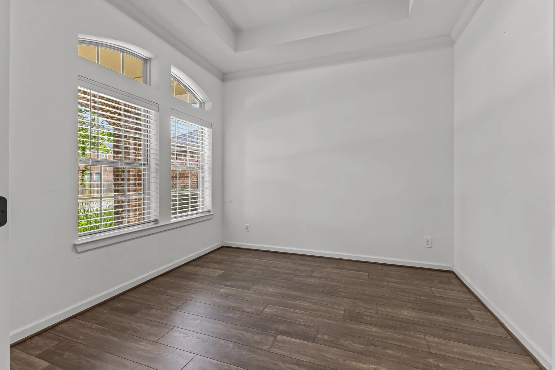 Bright flex room with wood flooring and large windows