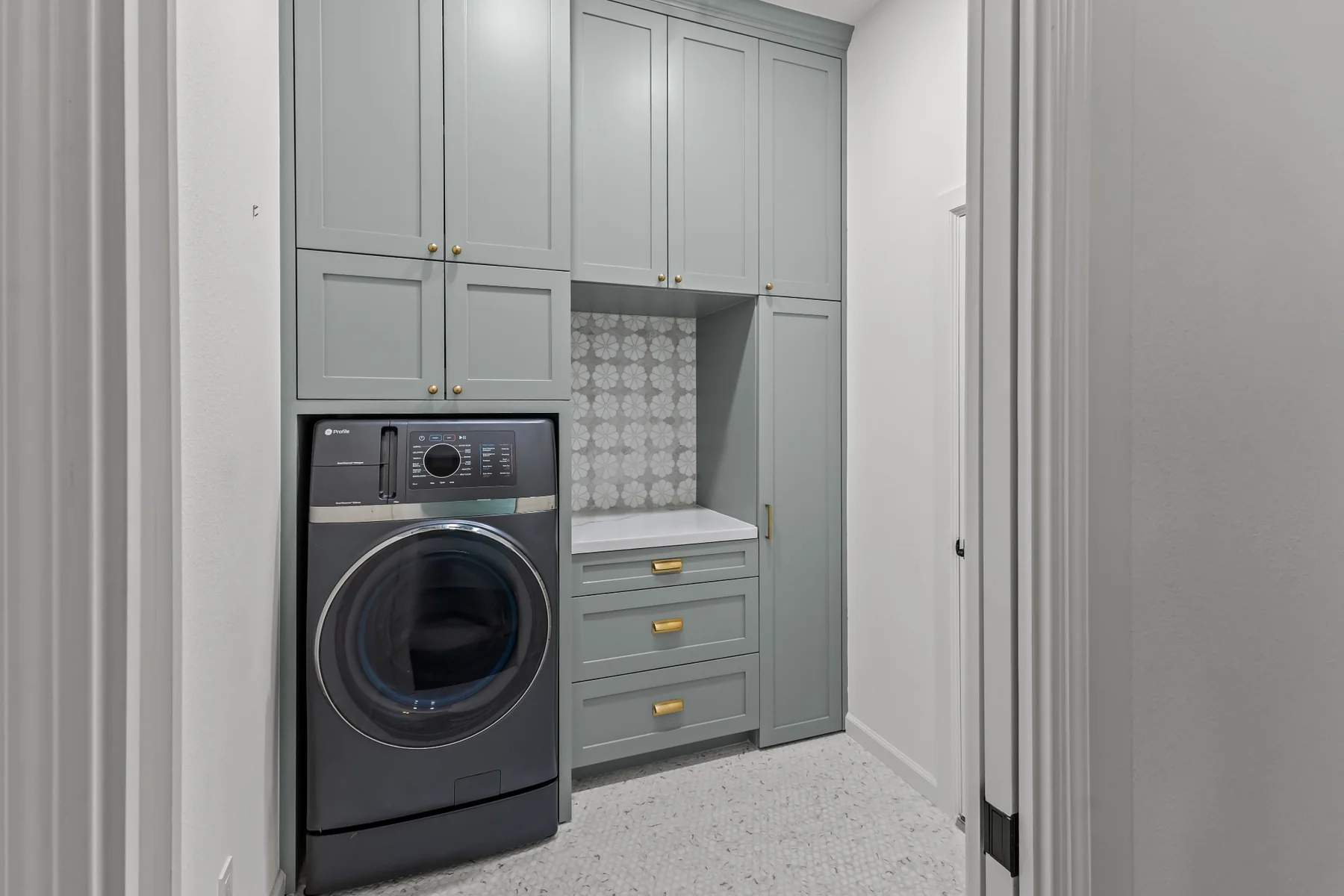 Custom laundry room with built-in cabinetry and storage
