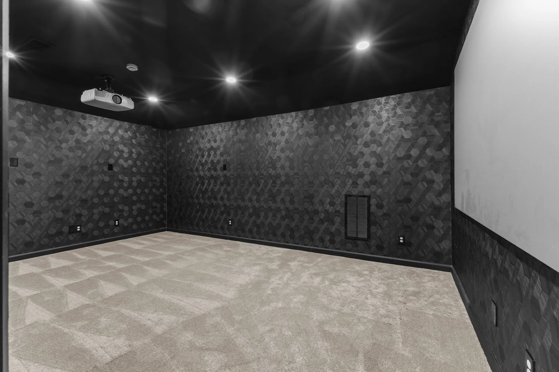 Dedicated dark media room with projector and geometric wall treatment