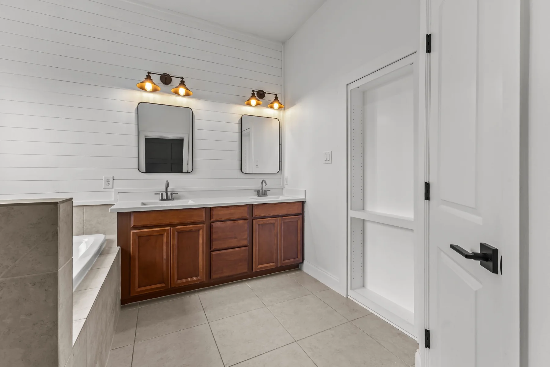 Primary bathroom with double vanity and shiplap accent wall