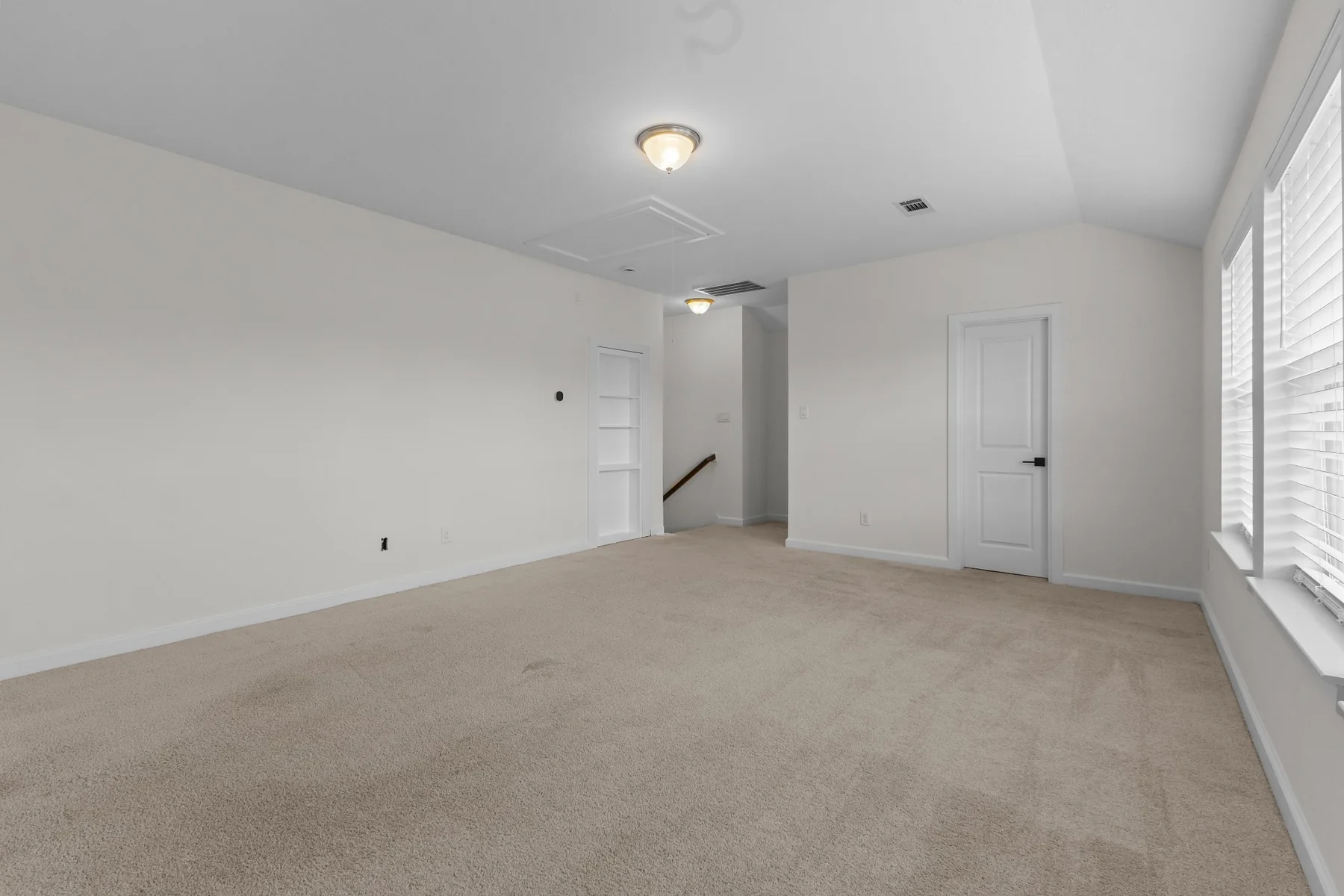 Spacious upstairs bonus room with neutral carpet