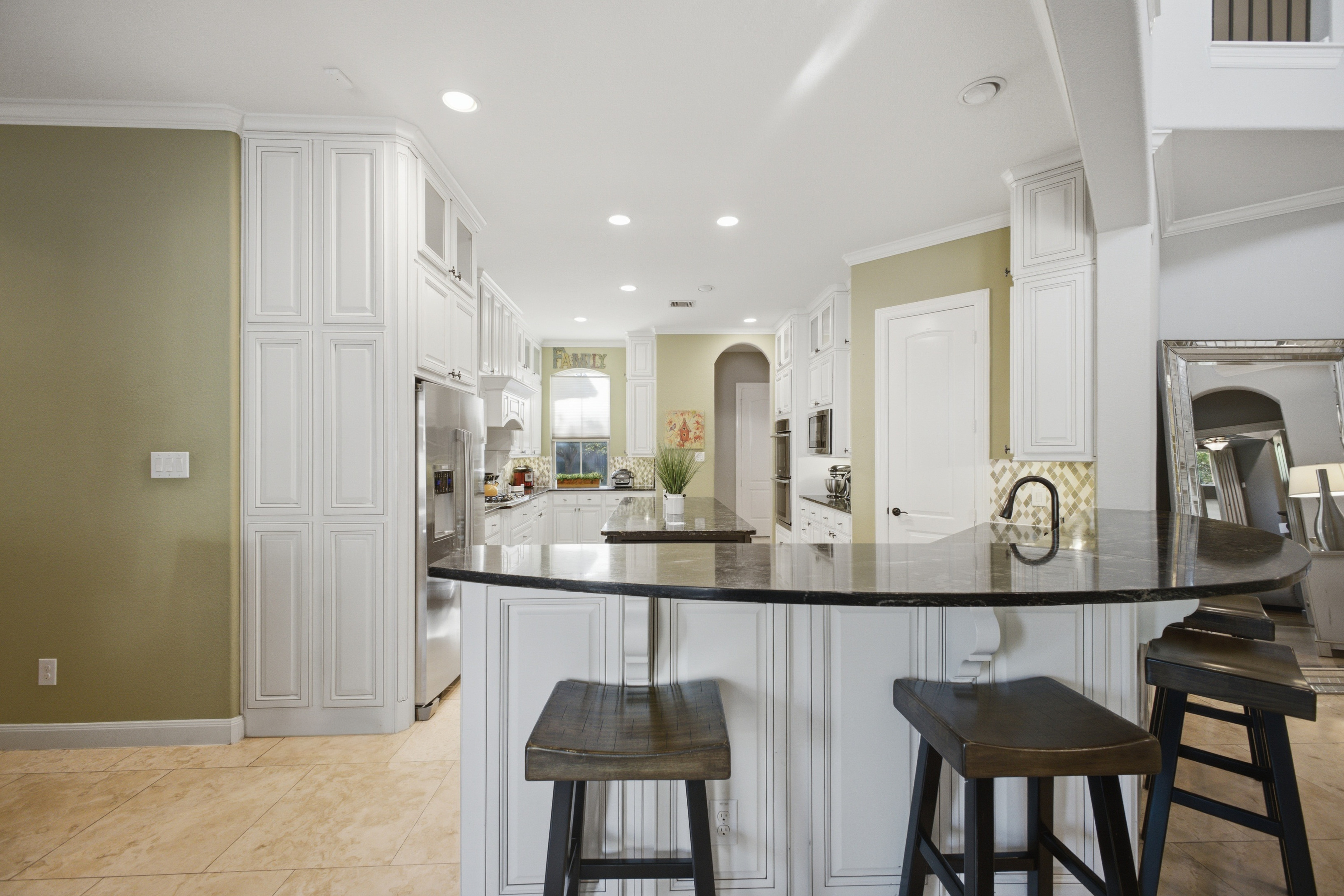 White kitchen with dark countertops and breakfast bar