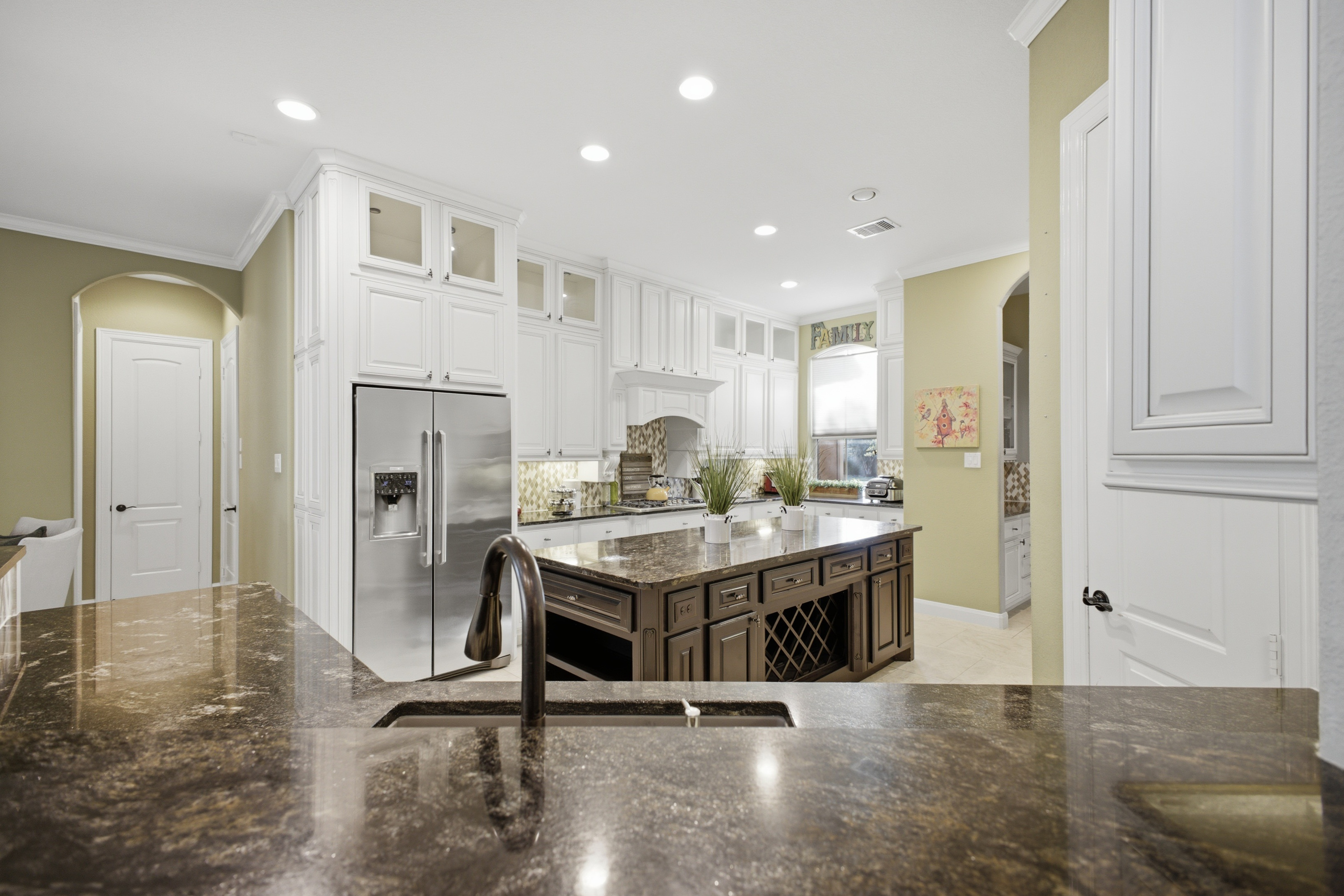 Large kitchen with white cabinetry and center island
