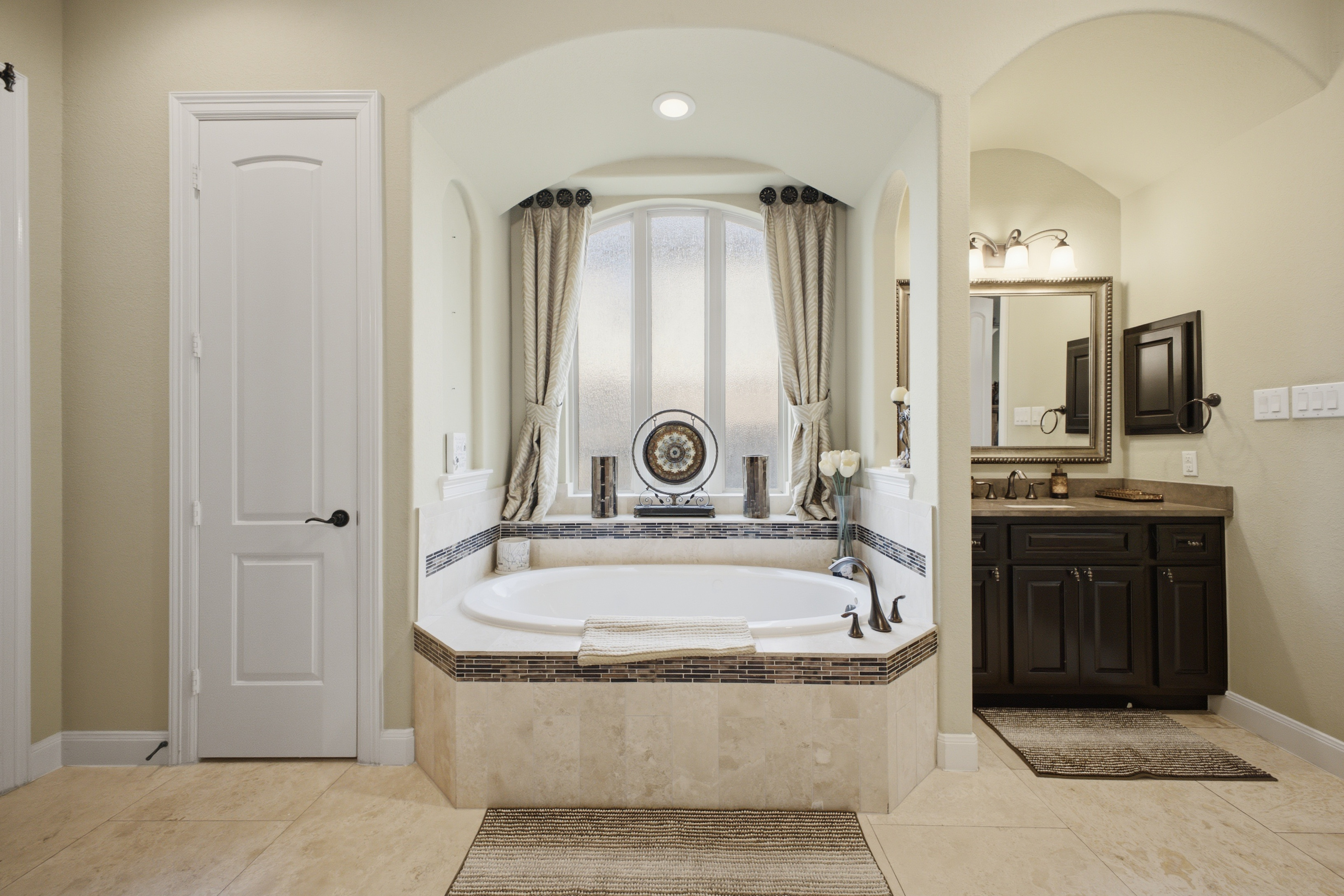 Primary bathroom with soaking tub and arched window