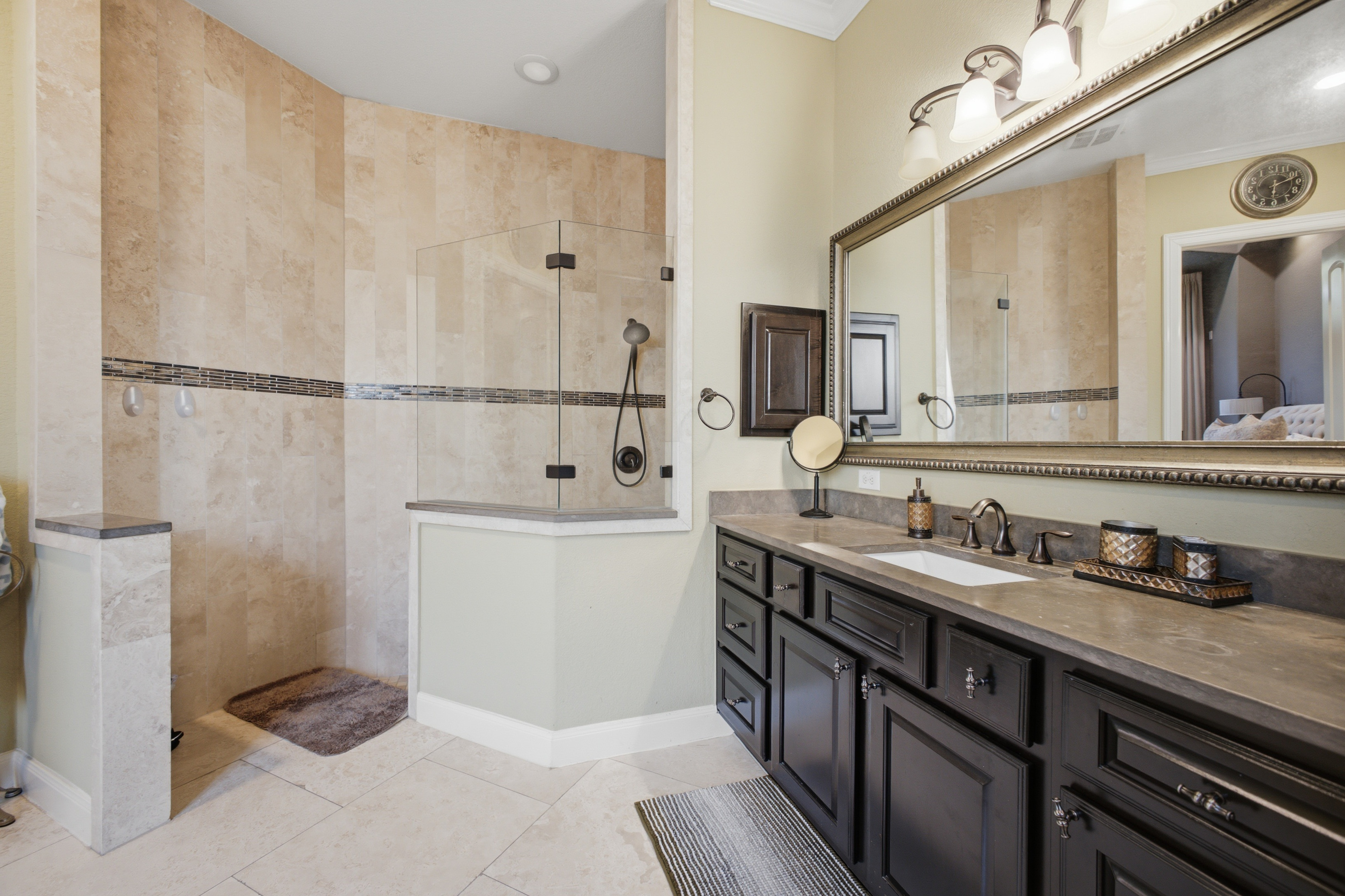Primary bathroom with glass shower and dark vanity