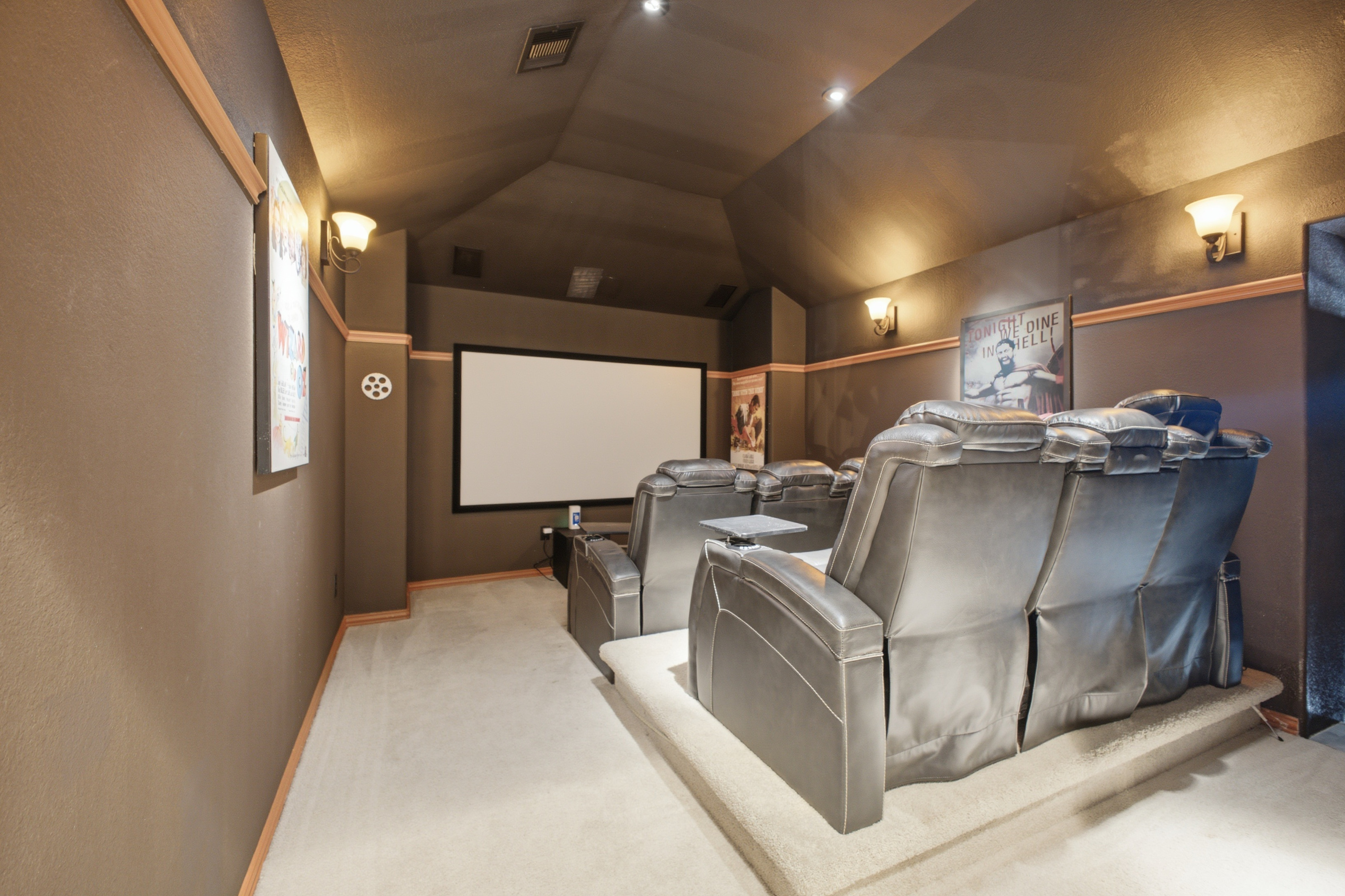Dedicated home theater with projection screen and tiered seating