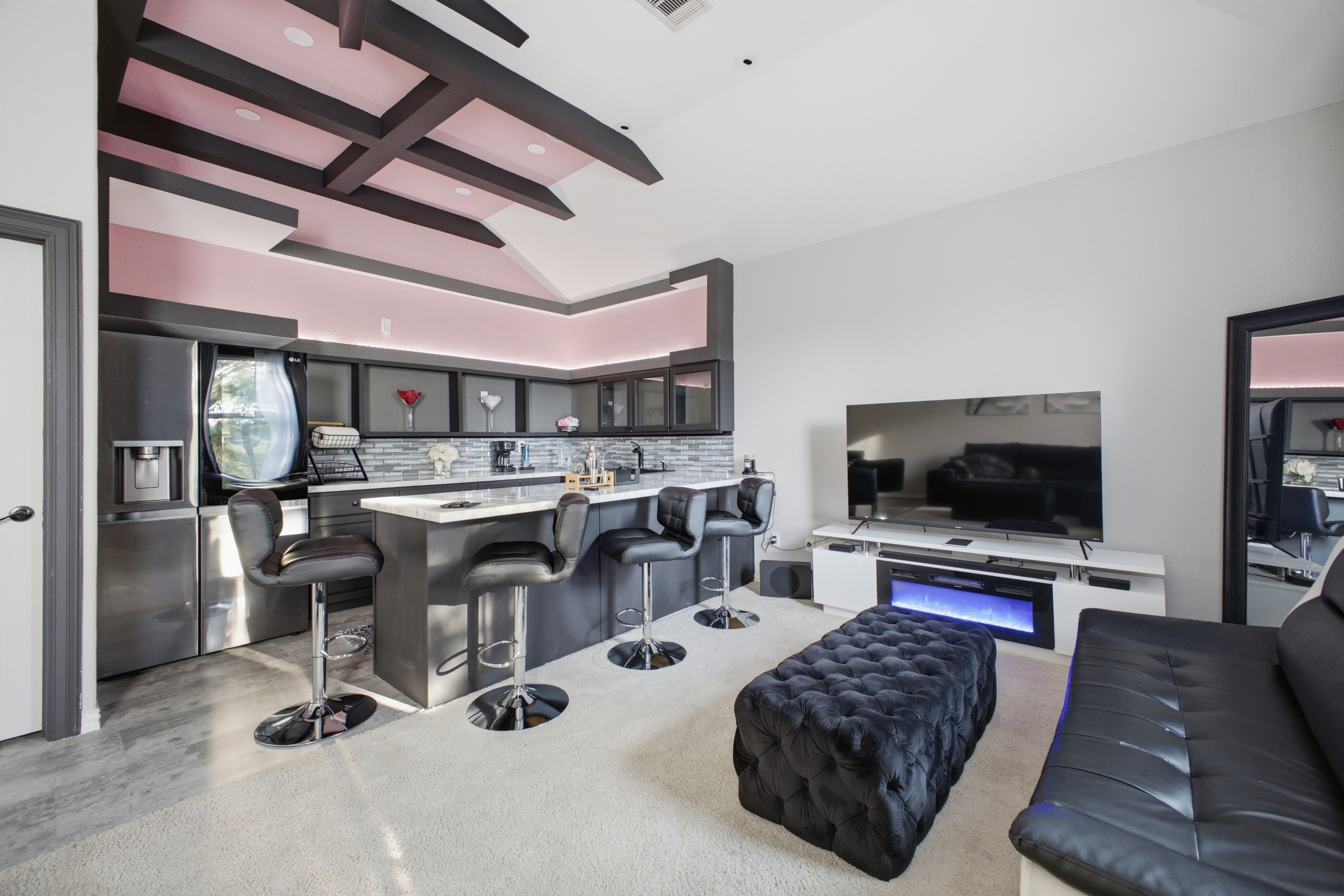 Upstairs entertainment room with wet bar and large television