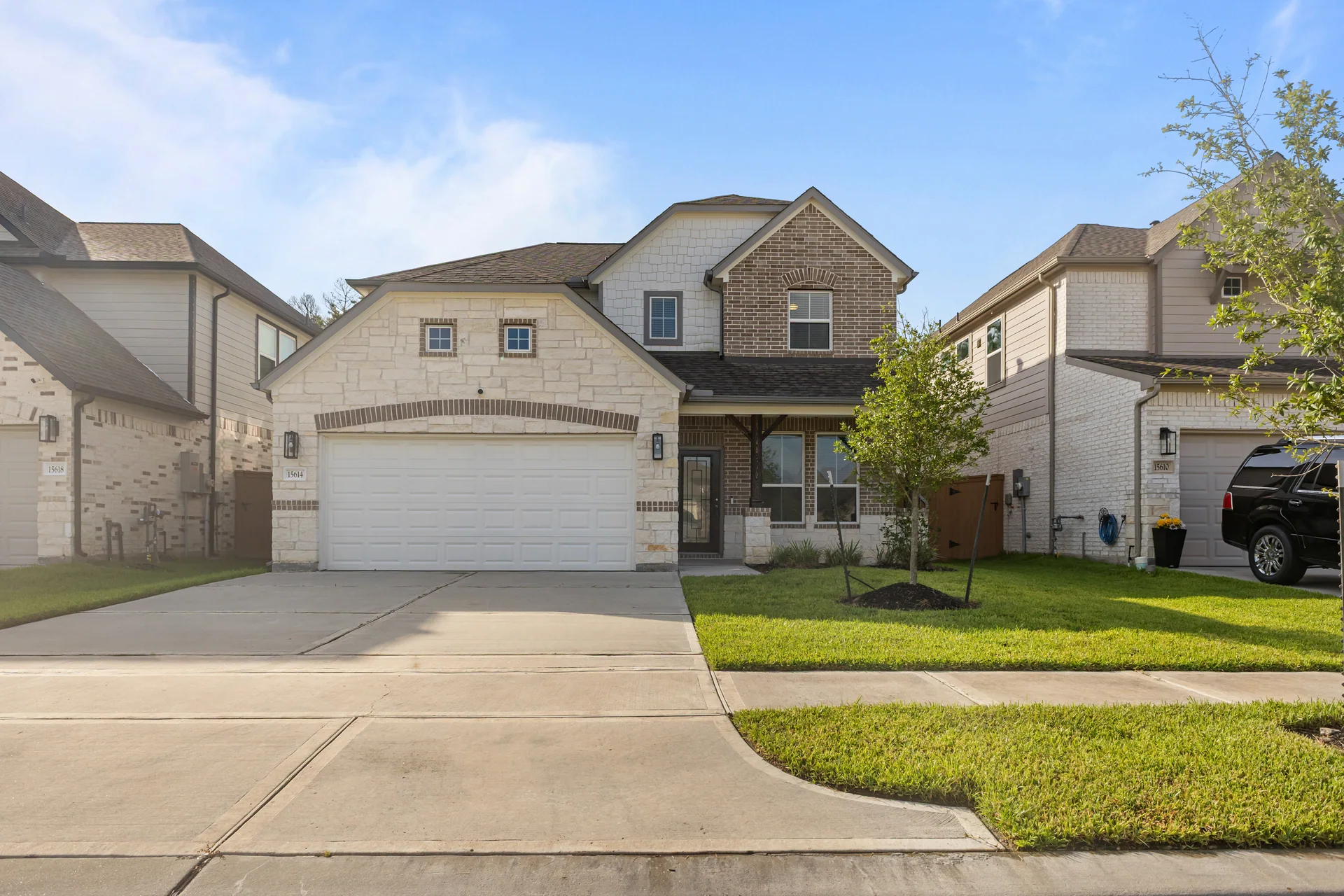 Front exterior of a two-story brick and stone suburban home